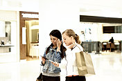 两个年轻的女孩一起出去购物。