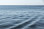 海浪纹理与船在遥远的地平线上