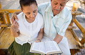 一对退休的老年夫妇在读一本书