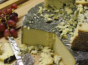 一堆奶酪/蓝斯蒂尔顿奶酪，康沃尔雅格奶酪蛋糕放在木板上