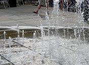 人行道上的喷泉，水喷过铺路板