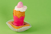 迷你蛋糕与粉色复活节彩蛋在绿色的背景