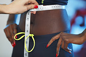 两个女人用卷尺测量自己的身体