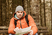 冬天在树林里徒步旅行看地图的人