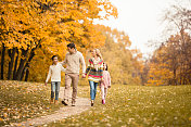 一家人走在秋天的小路上