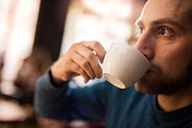 一个男人喝咖啡的特写。