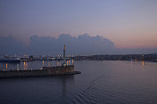 墨西拿海港的景色和远处的云彩，日出
