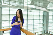迷人的长发亚洲女人发短信与智能手机