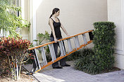 “向前一步”――真正的女建筑工人在屋外搬运梯子