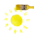 画笔用黄色颜料(在白色上)画着太阳