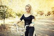 在森林里骑自行车的年轻金发女人