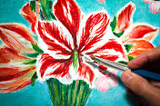 画红花的艺术家;手用画笔特写