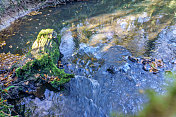 在林地溪流中流过岩石的水