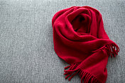 灰色沙发上的红色羊毛围巾