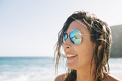 一个年轻女子的海滩肖像，背光在阳光下。