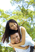 快乐的年轻亚洲夫妇一起在公园户外