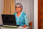 在家里用笔记本电脑工作的西班牙老妇人被打扰了