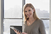 年轻女商人微笑着拿着平板电脑的肖像