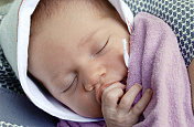 新生婴儿吮吸着手指安静地睡觉