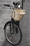 自行车与柳条篮子-自行车停在城市街道